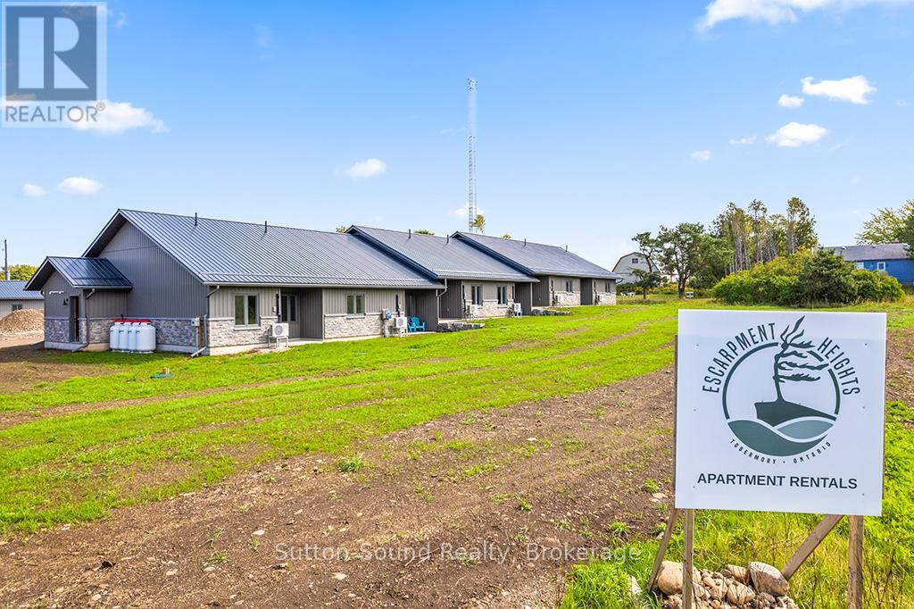 A sign for Environmental Apartments is in front of a building.