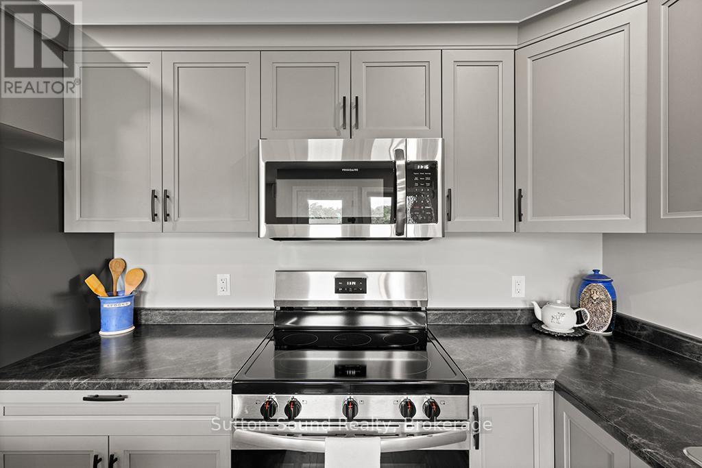 A modern kitchen with a stainless steel stove and microwave above it.