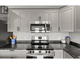 A modern kitchen with a stainless steel stove and microwave above it.
