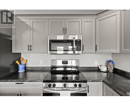 A modern kitchen with a stainless steel stove and microwave above it.