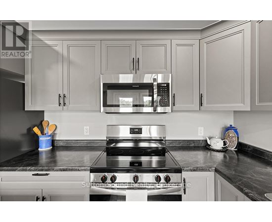A modern kitchen with a stainless steel stove and microwave above it.