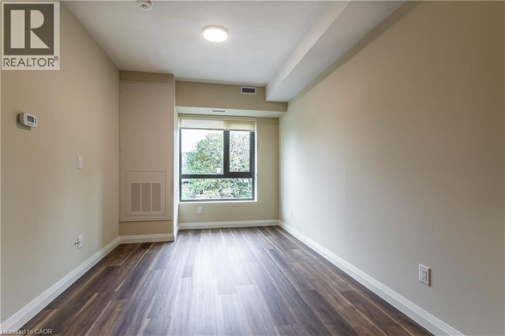 A spacious room with wooden floors and a large window.