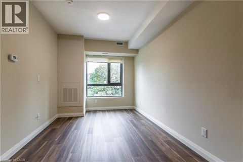A spacious room with wooden floors and a large window.