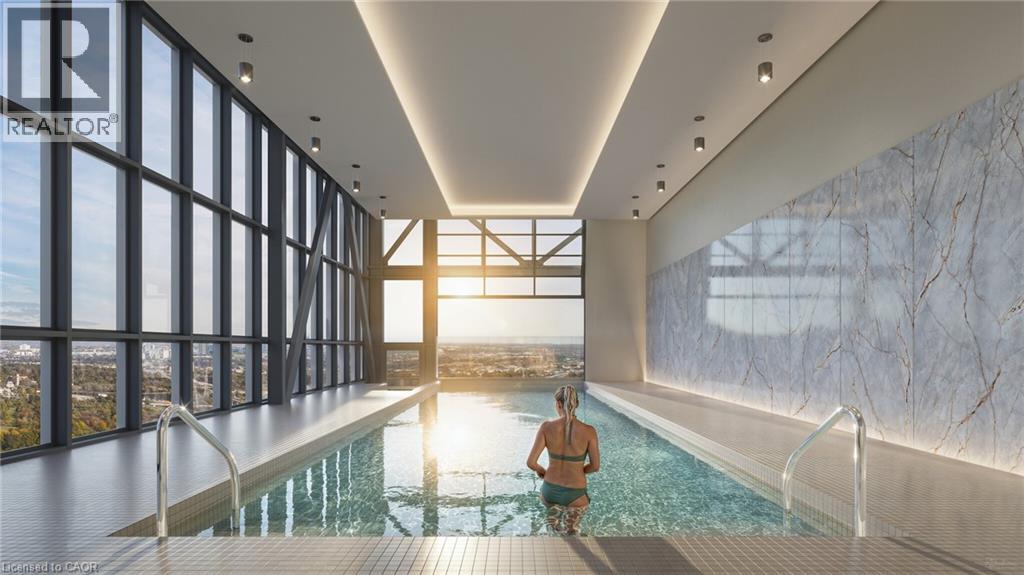 A woman is sitting in a pool in a large room with a marble wall.