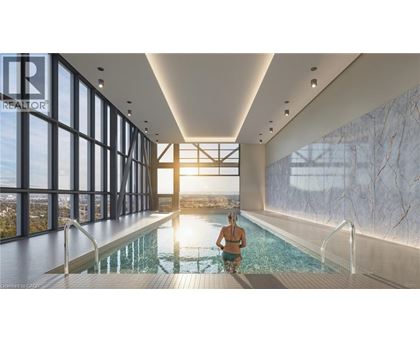A woman is sitting in a pool in a large room with a marble wall.