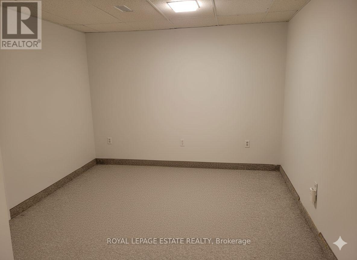 A bedroom with a bed covered in a white comforter.