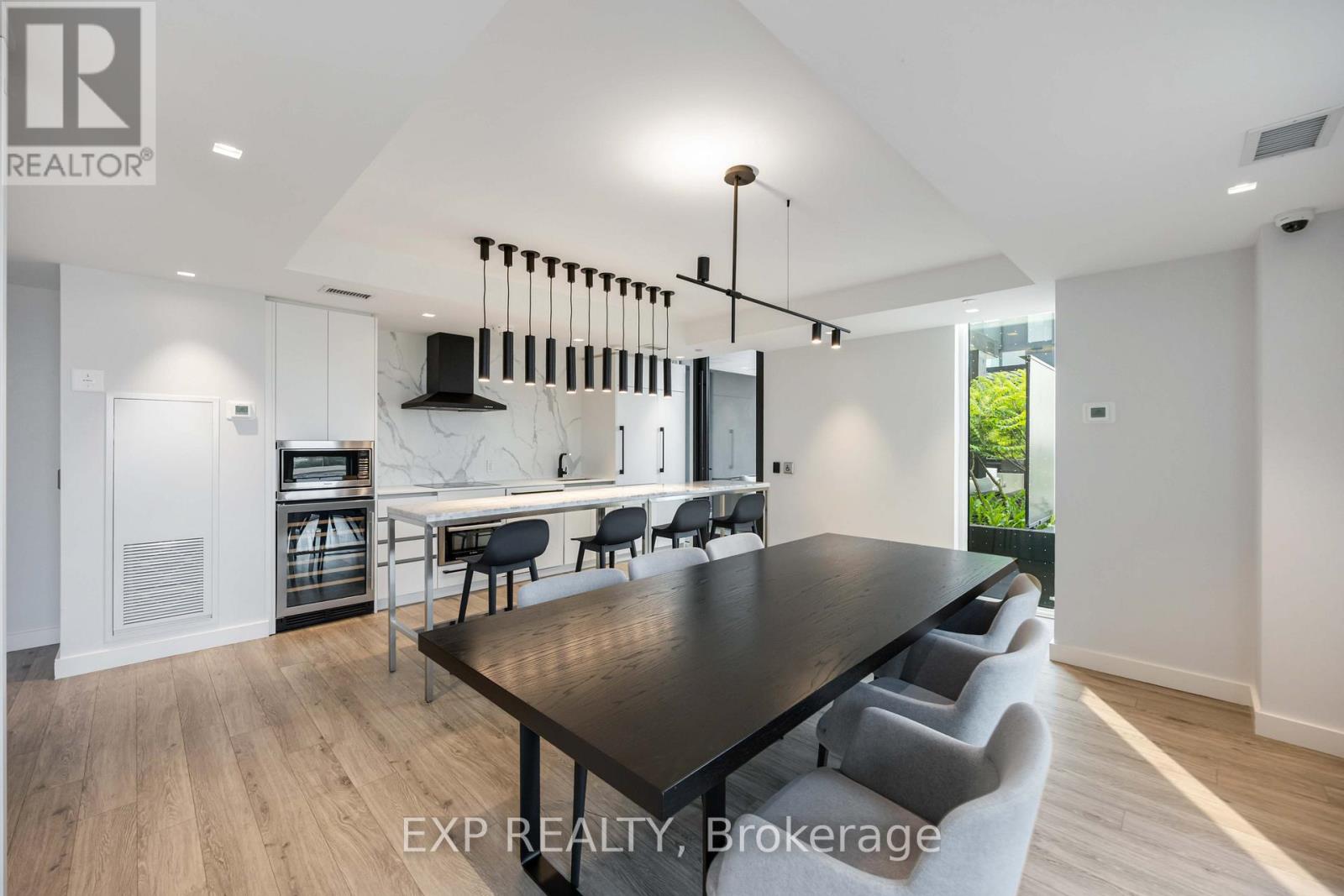 A modern dining room with a long table and chairs.