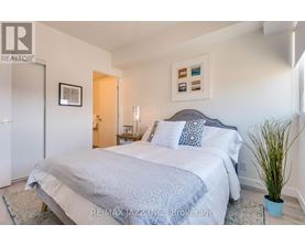 A bedroom with a large bed and a potted plant.