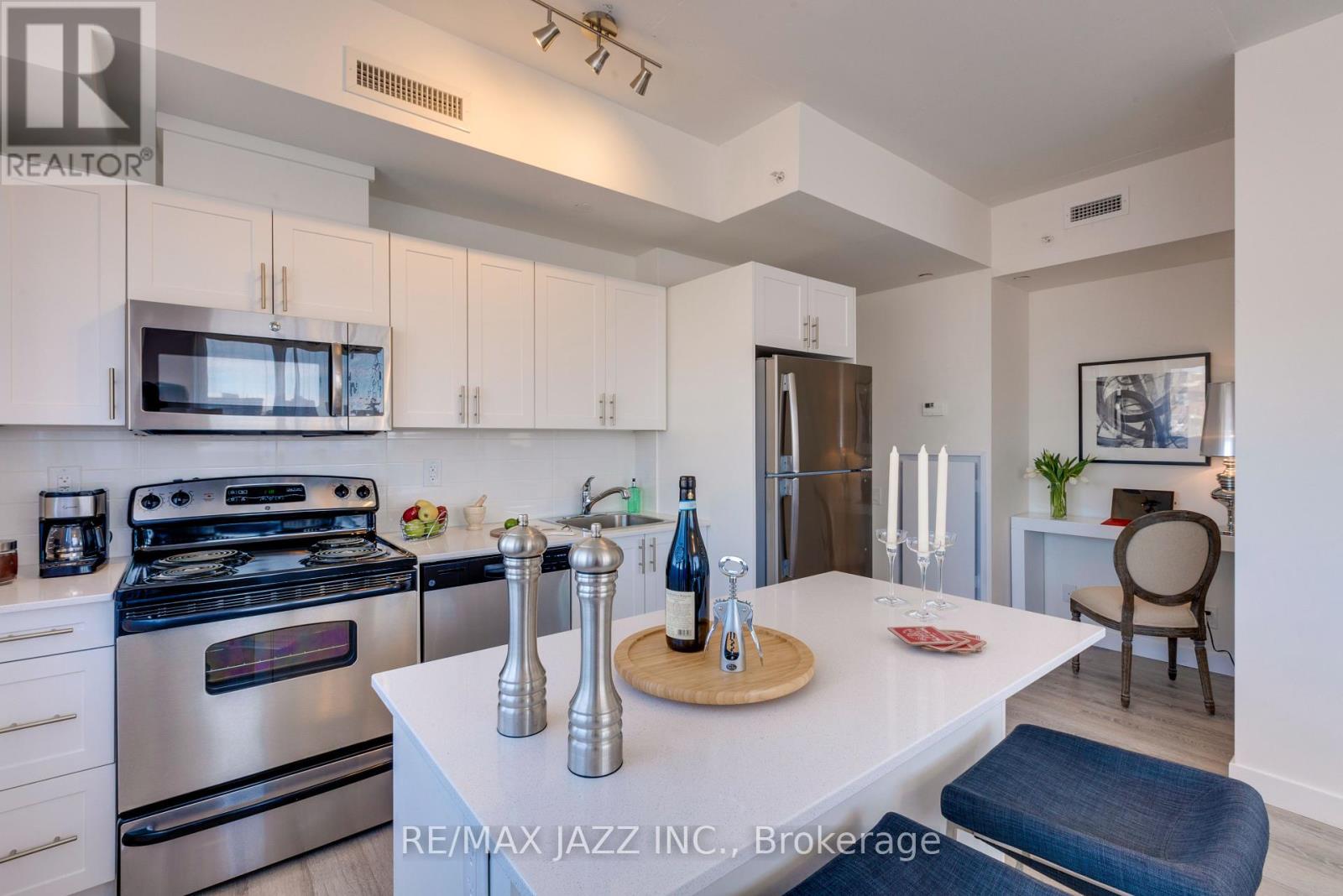 A modern kitchen with white cabinets and stainless steel appliances.