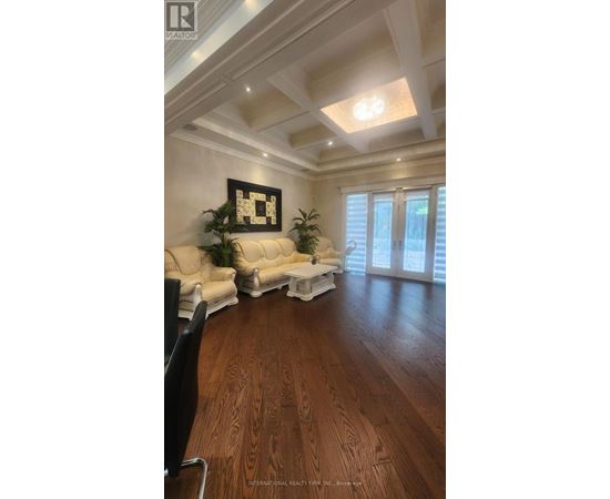A living room with a white sofa and a wooden floor.