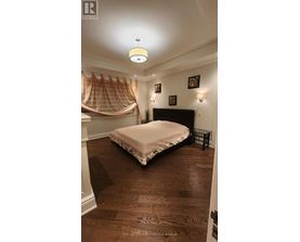 A bedroom with a bed, a canopy, and pictures on the wall.