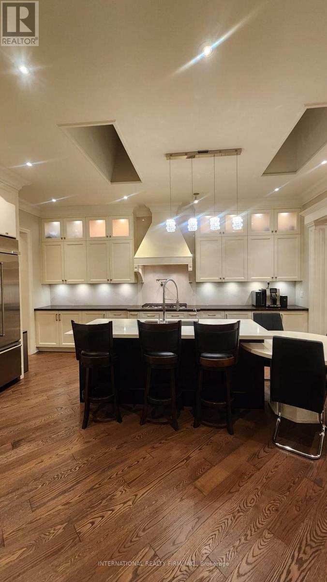 A modern kitchen with a dark wood floor and white cabinets.