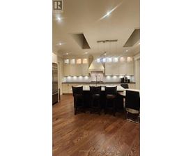 A modern kitchen with a dark wood floor and white cabinets.
