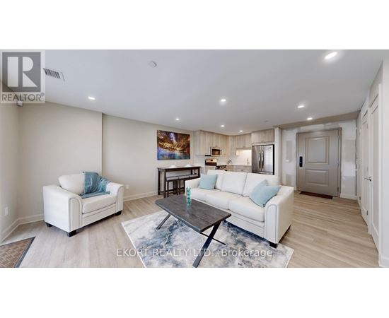 A living room with a white couch, a coffee table, and a painting on the wall.