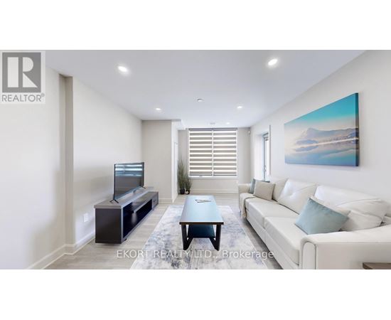 A living room with a white couch, a television, and a painting on the wall.
