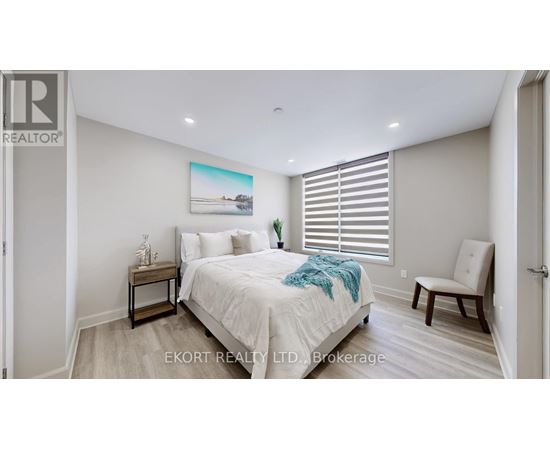 A bedroom with a bed, nightstand, and chair.
