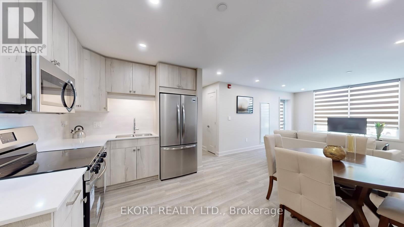 A modern kitchen with white cabinets and stainless steel appliances.