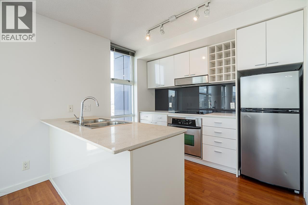 A kitchen with white cabinets and a stainless steel refrigerator.