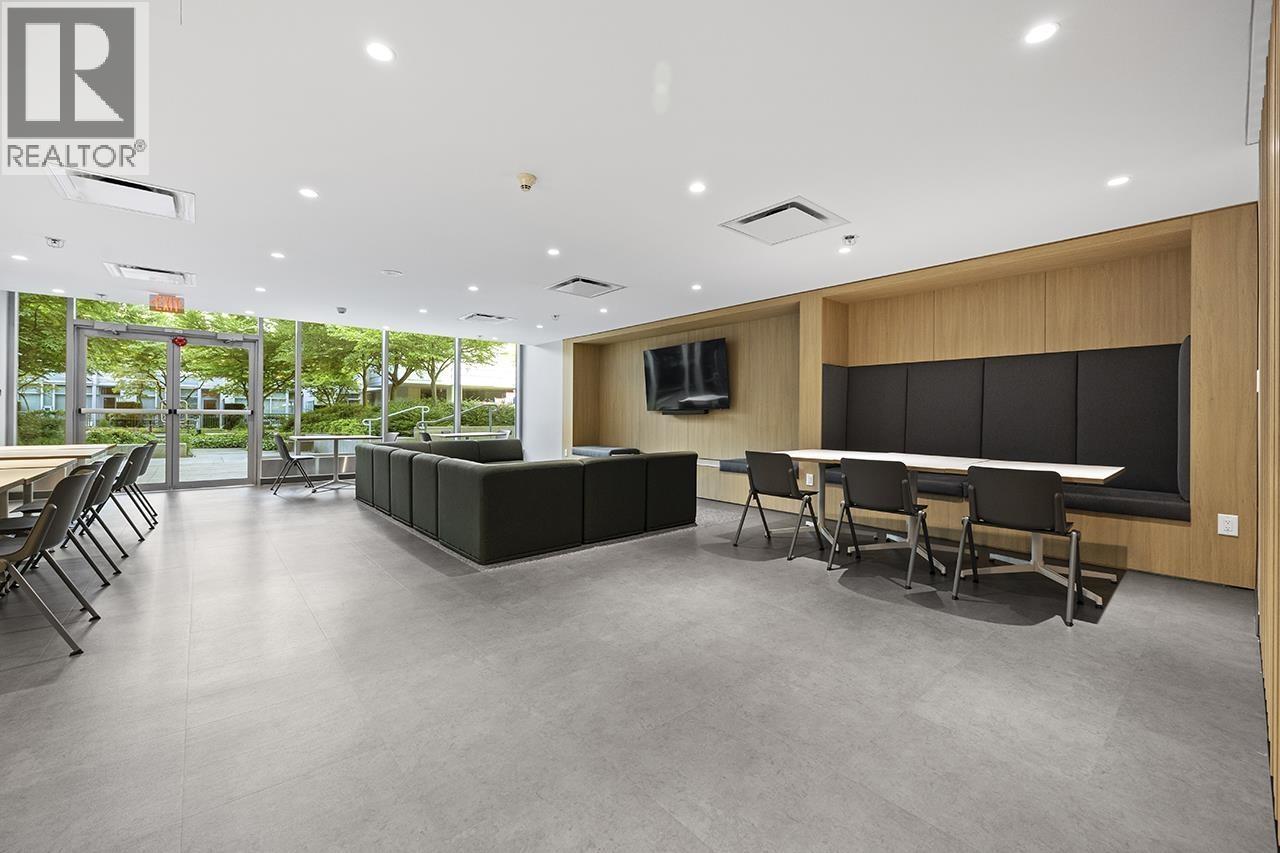 A conference room with a long table and chairs, a television, and a reception desk.