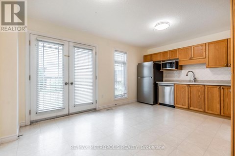 A kitchen with wooden cabinets and a black refrigerator.