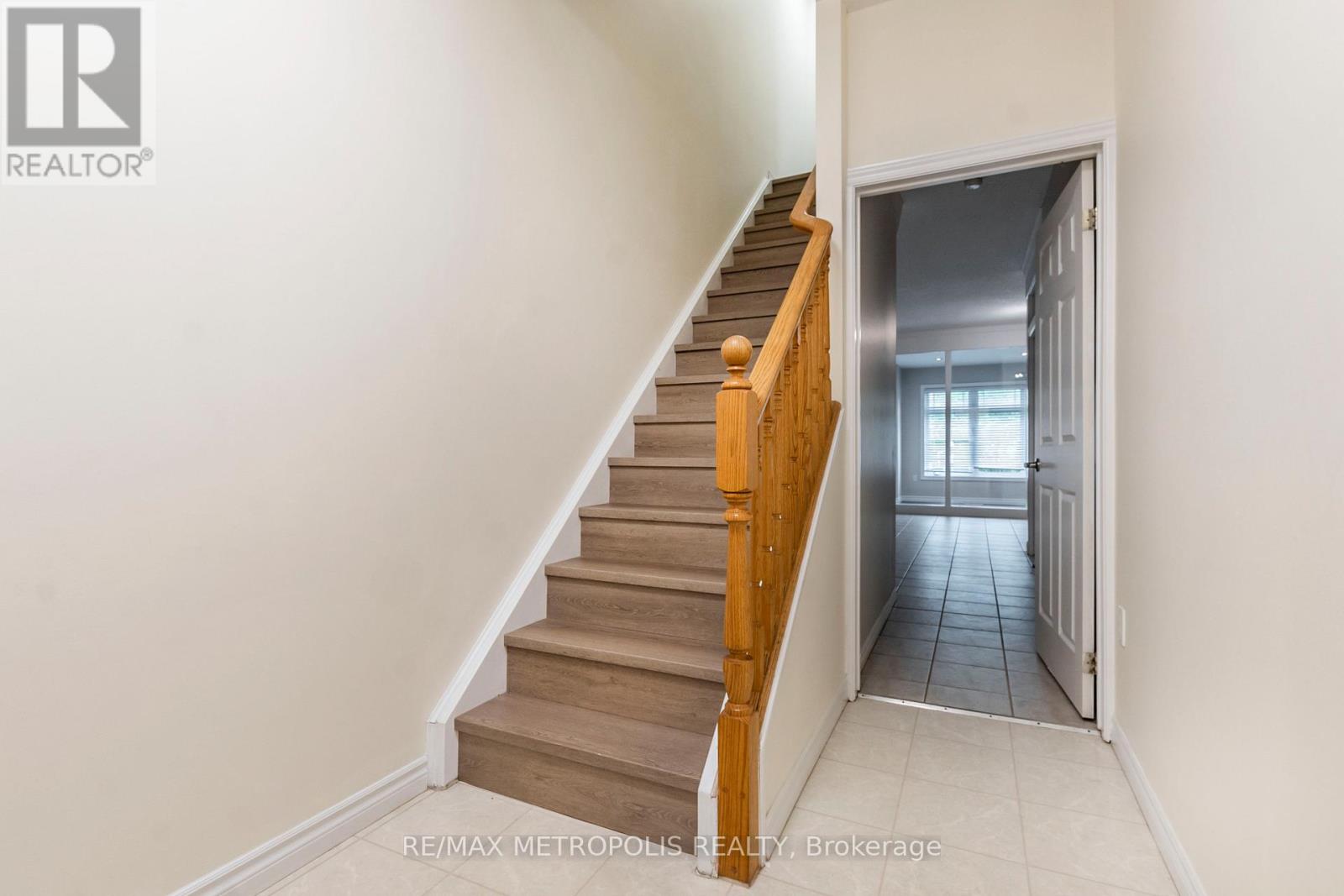A staircase with wooden steps and a white wall.