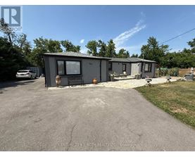 A grey building with a sign that says "Century 21 B.J. Roth Realty LTD Brokerage" in front of it.