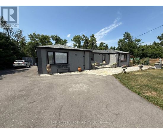 A grey building with a sign that says "Century 21 B.J. Roth Realty LTD Brokerage" in front of it.
