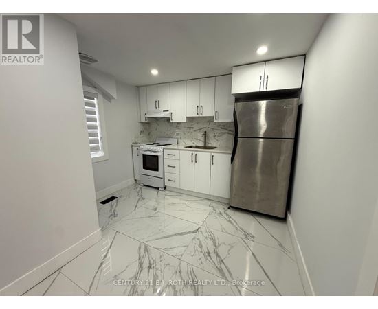 A kitchen with white cabinets and a marble floor.