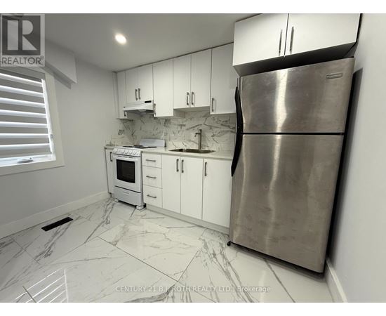A kitchen with white cabinets and a marble floor.