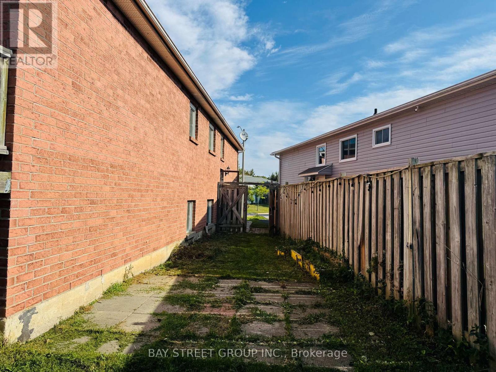 A red brick building with a wooden fence in front.