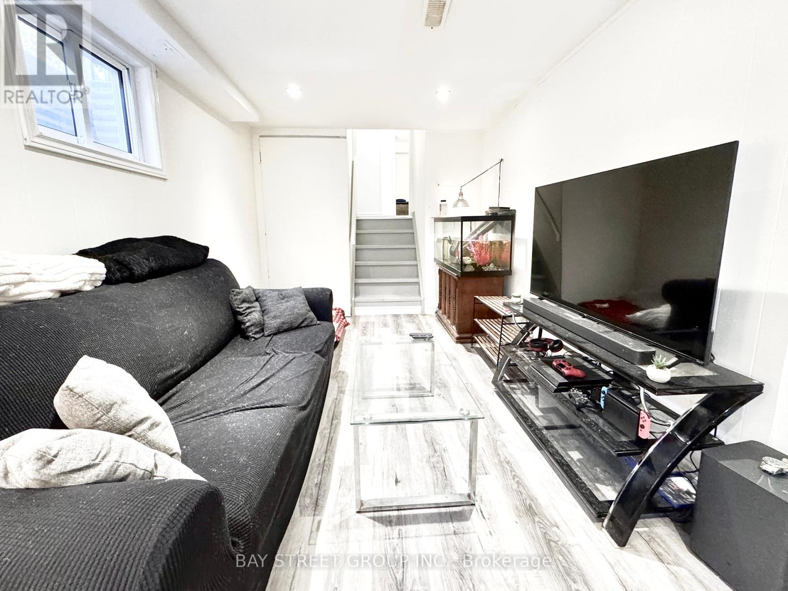 A living room with a grey couch and a television.