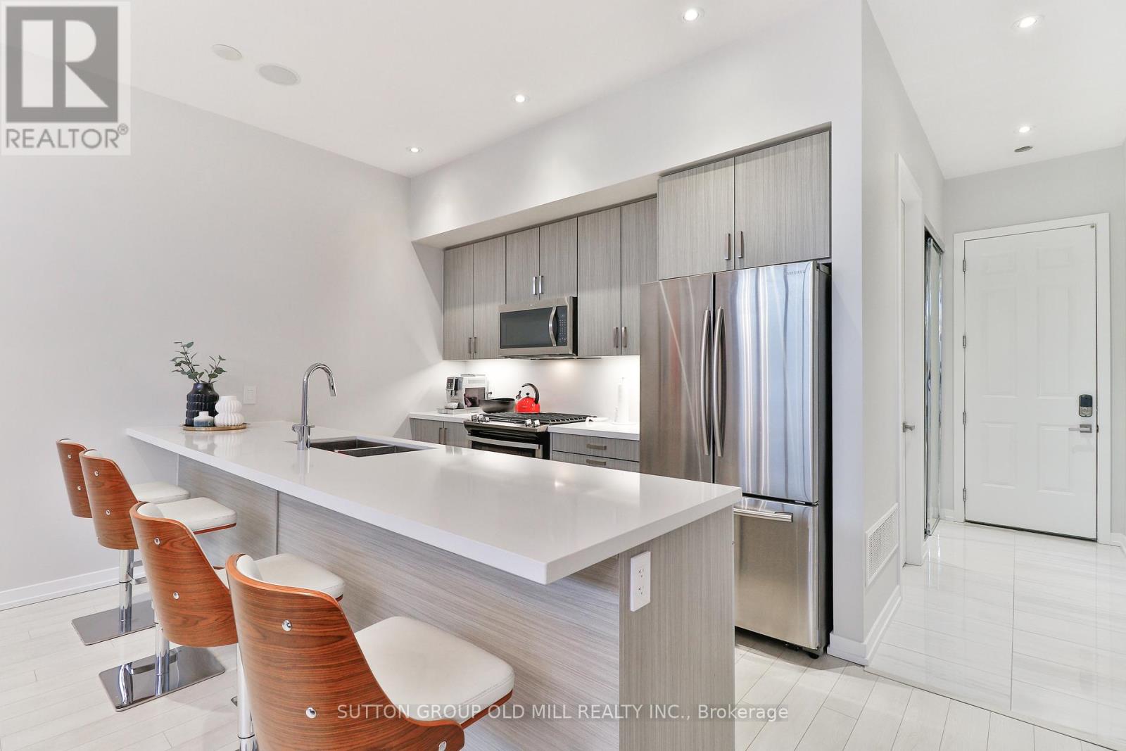 A modern kitchen with a stainless steel refrigerator and wooden cabinets.
