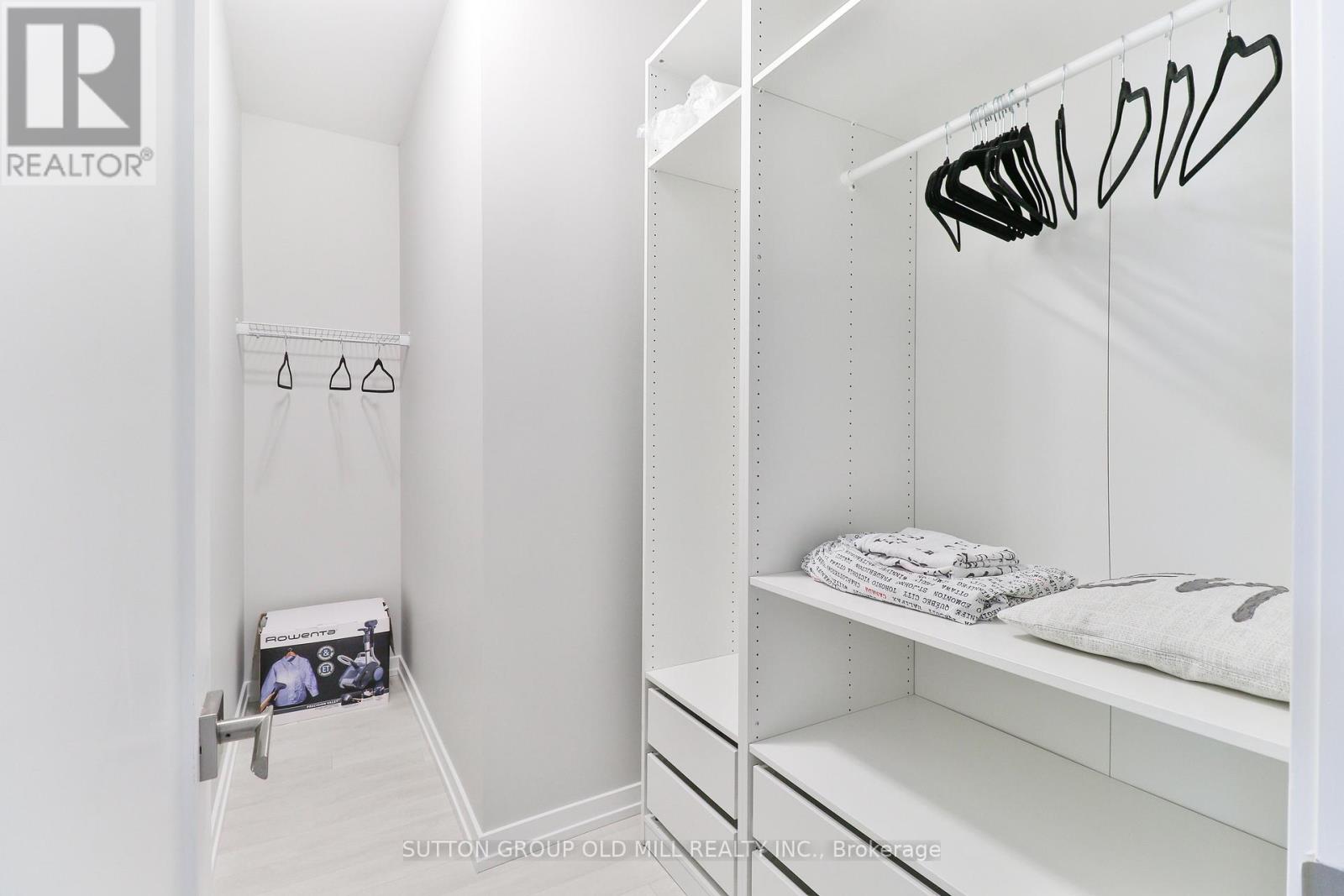 A white bedroom with a bed and a shelf.