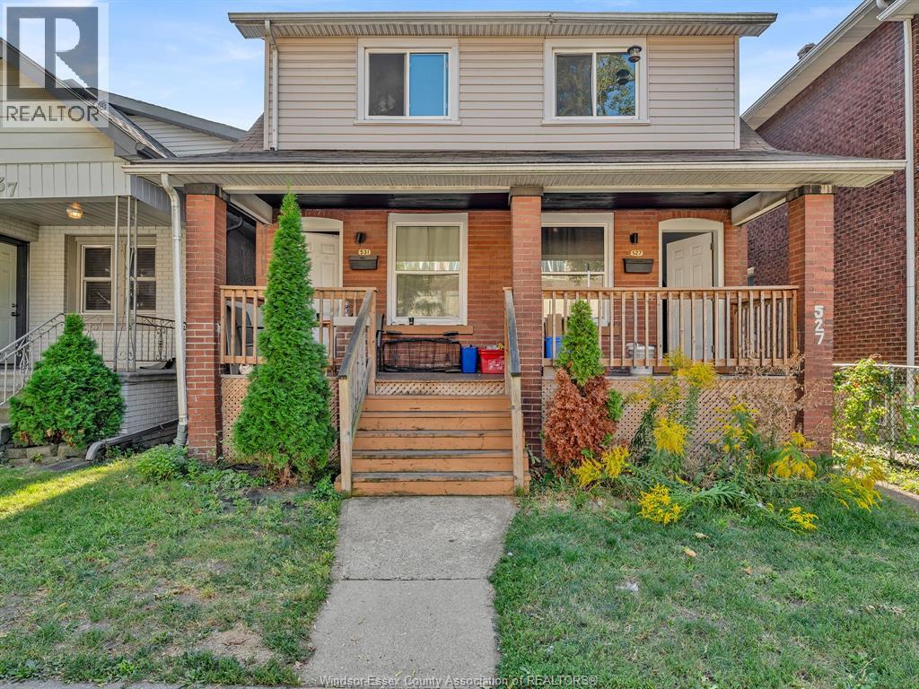 A house with a grey roof and a porch with a wooden railing.