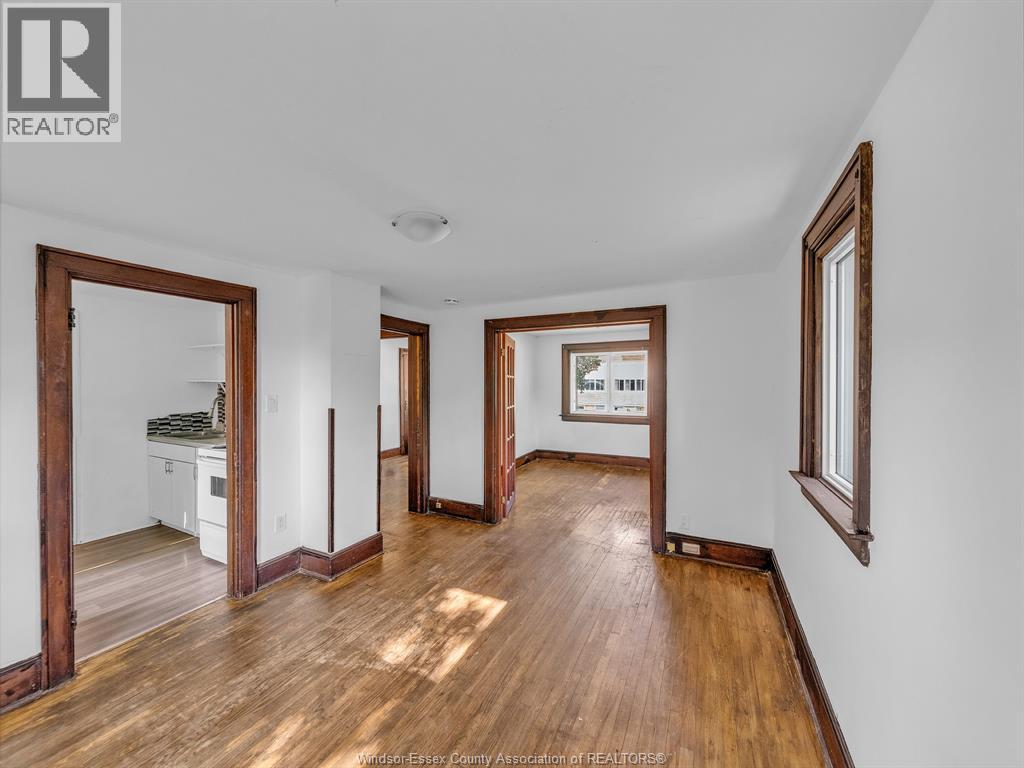 A spacious room with wooden floors and white walls.