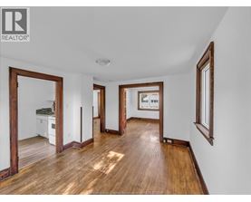 A spacious room with wooden floors and white walls.