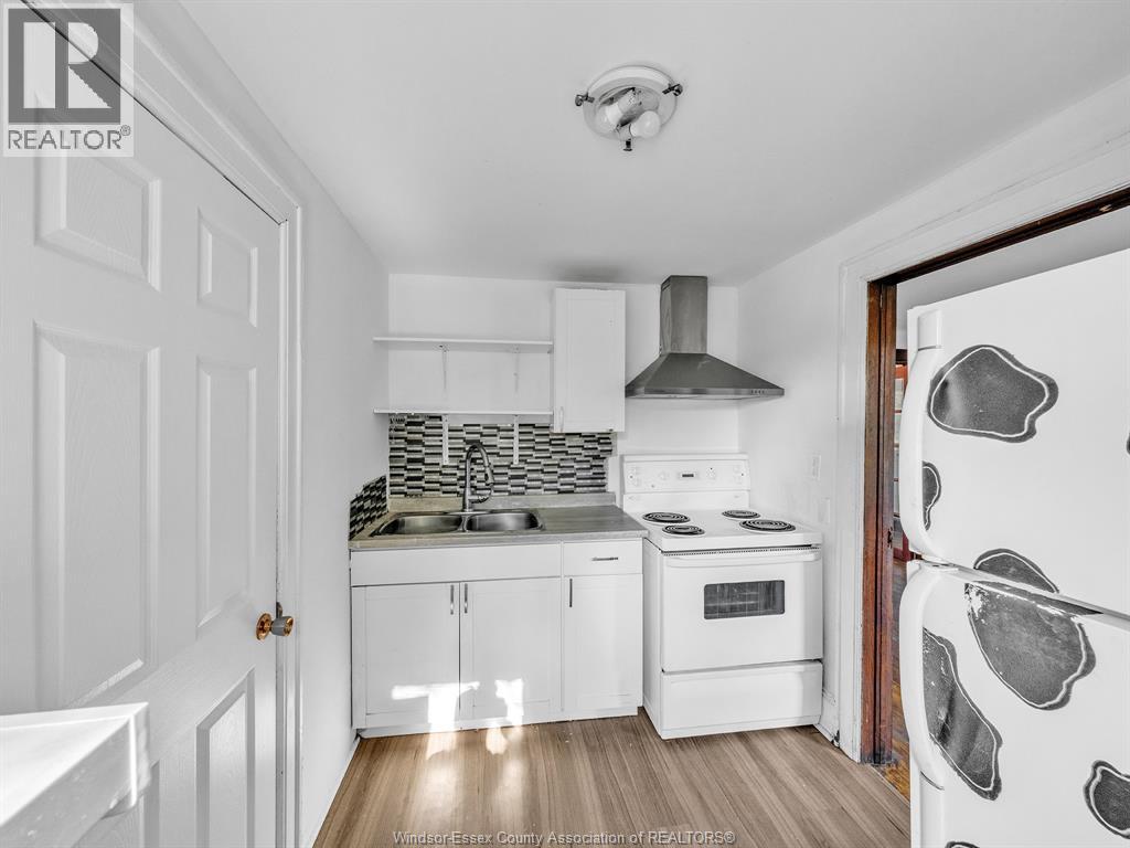 A kitchen with white cabinets and a white refrigerator.