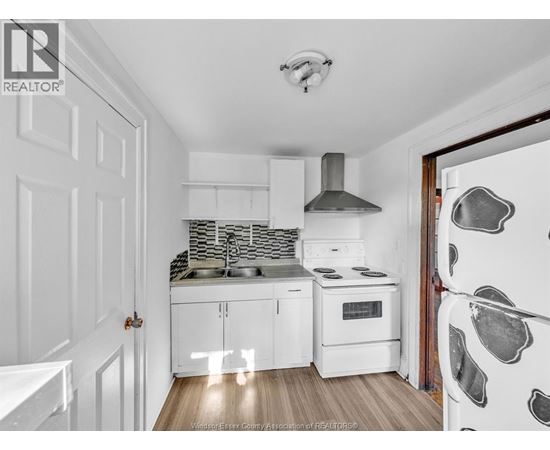 A kitchen with white cabinets and a white refrigerator.