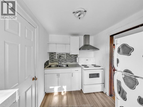 A kitchen with white cabinets and a white refrigerator.