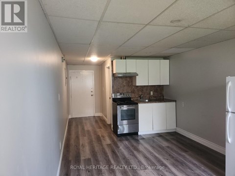 A kitchen with white cabinets and a stove top oven.