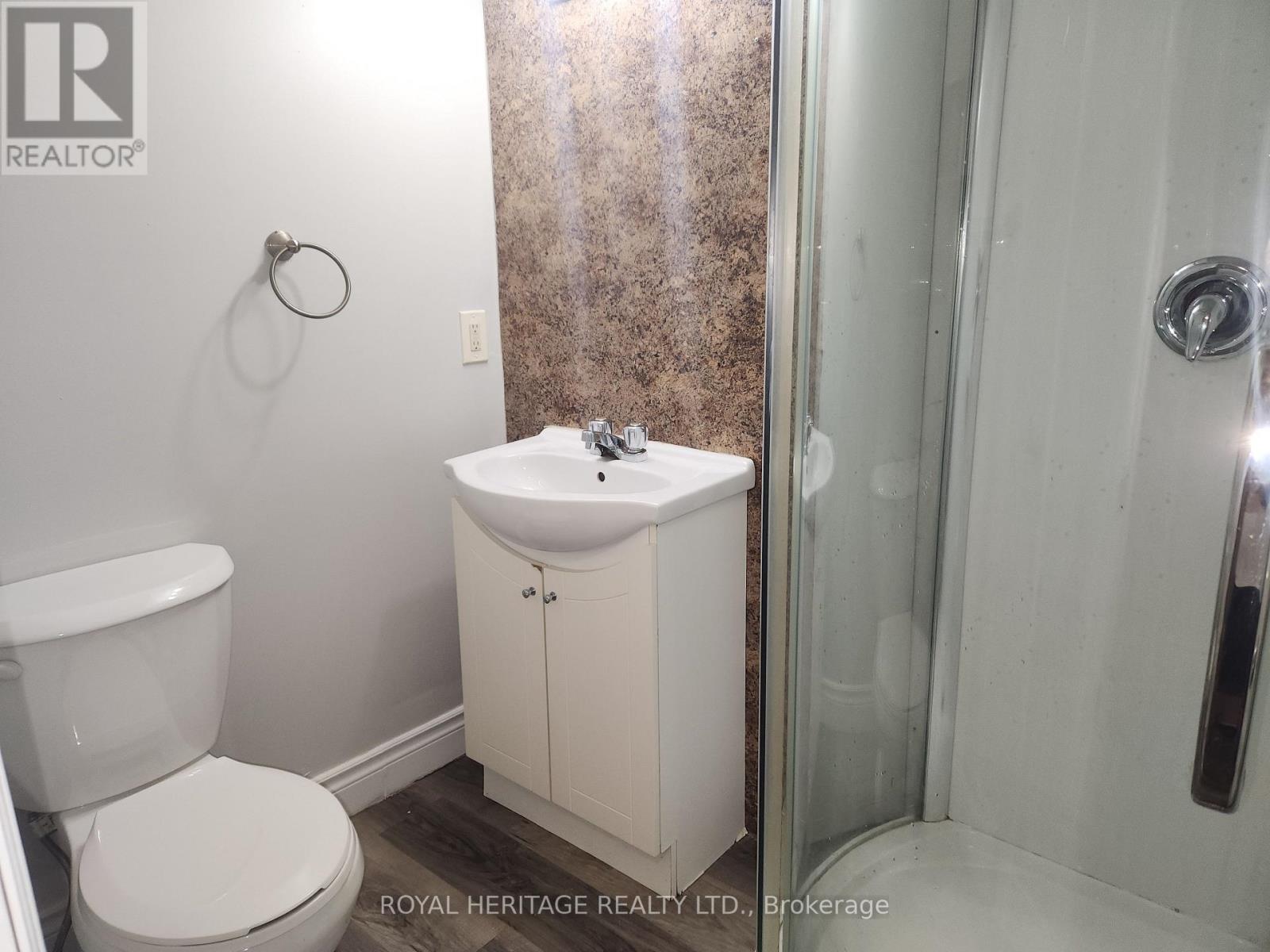 A white toilet sits next to a white sink in a small bathroom.