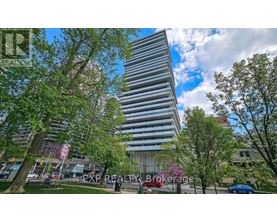A tall building with a striped facade stands in a park with trees and people walking around.
