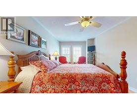 A bedroom with a bed in the center and a ceiling fan above it.