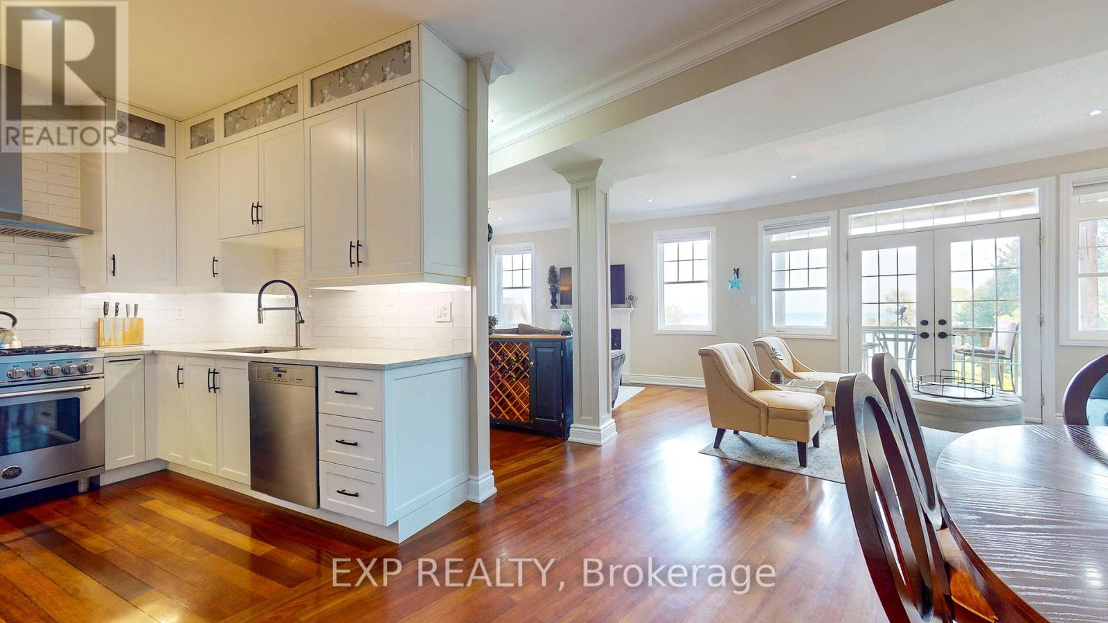 A kitchen with white cabinets and a wooden floor.