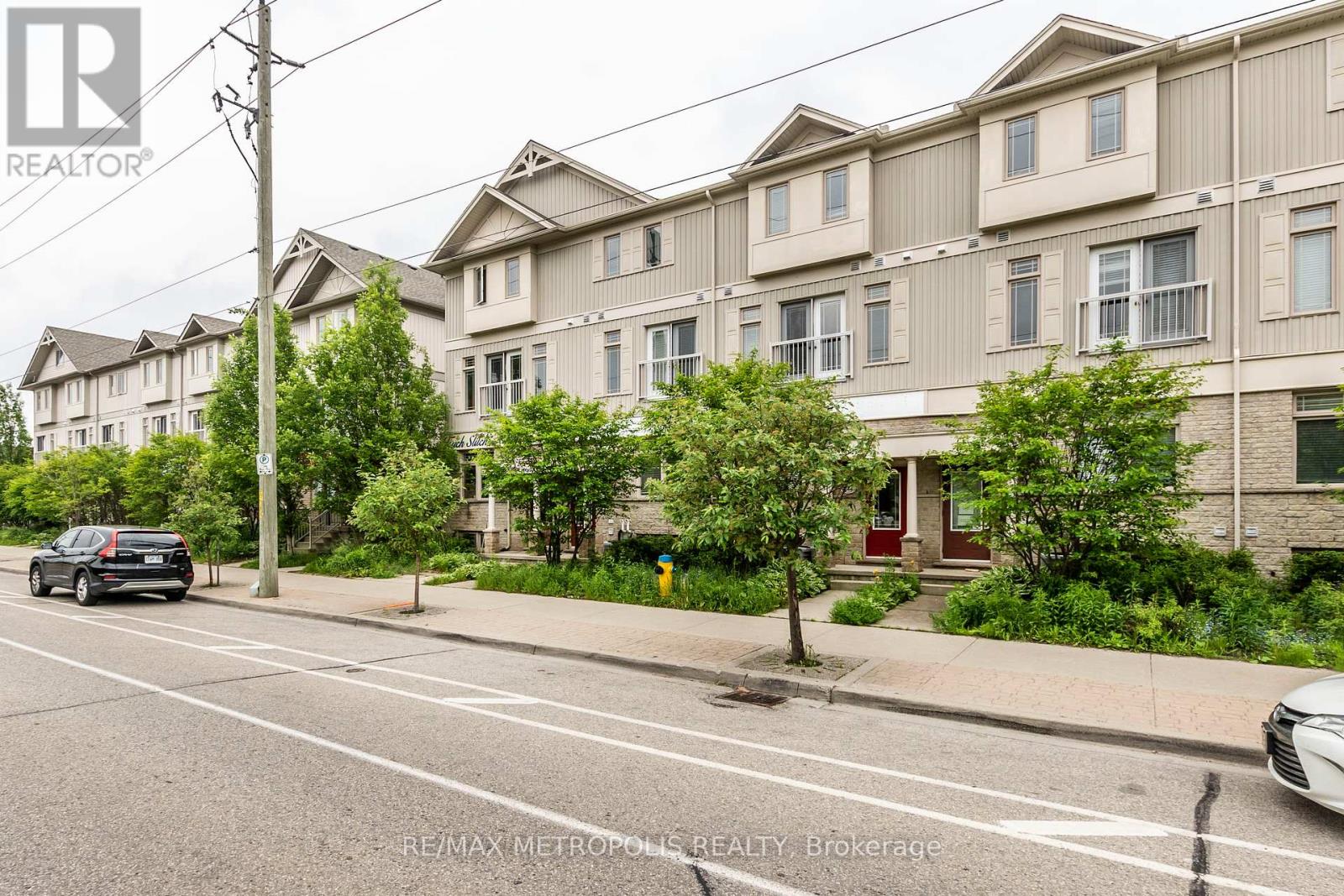 A street view of a residential area with apartment buildings and parked cars.