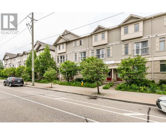 A street view of a residential area with apartment buildings and parked cars.