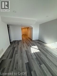 A room with wooden flooring and a doorway leading to another room.