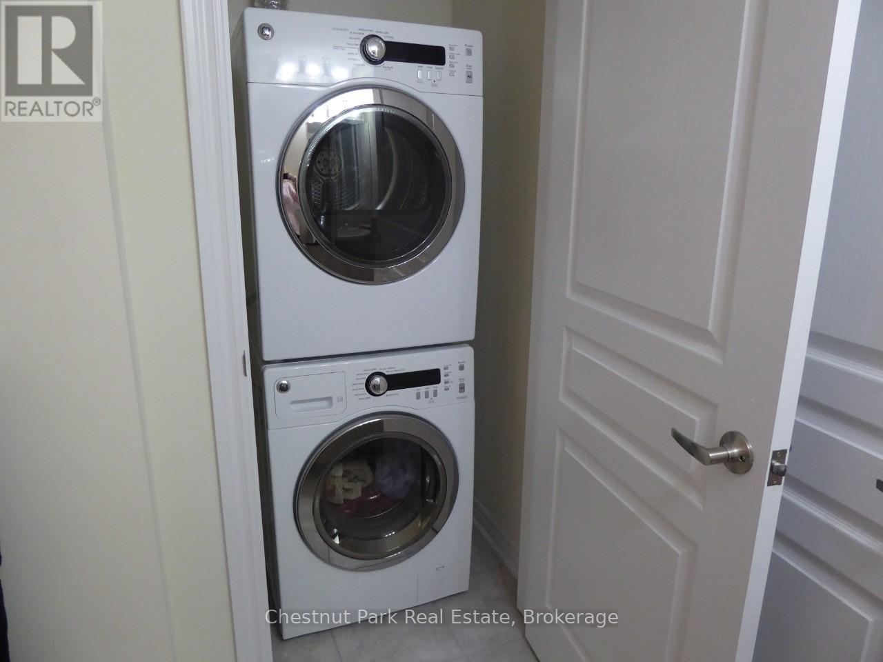A white washer and dryer stacked on top of each other in a small space.