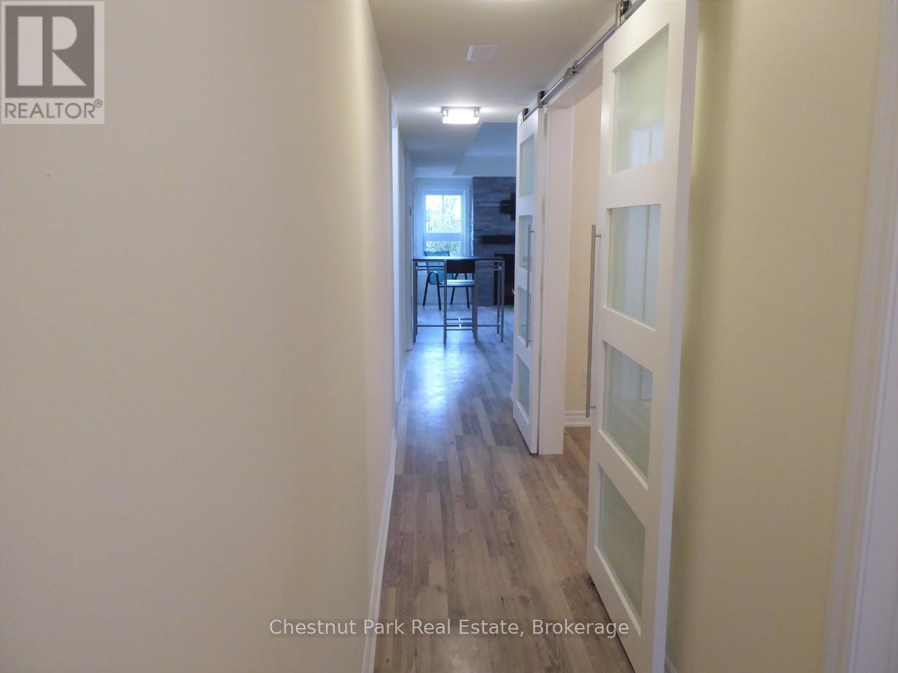 A hallway with wood floors and white walls.