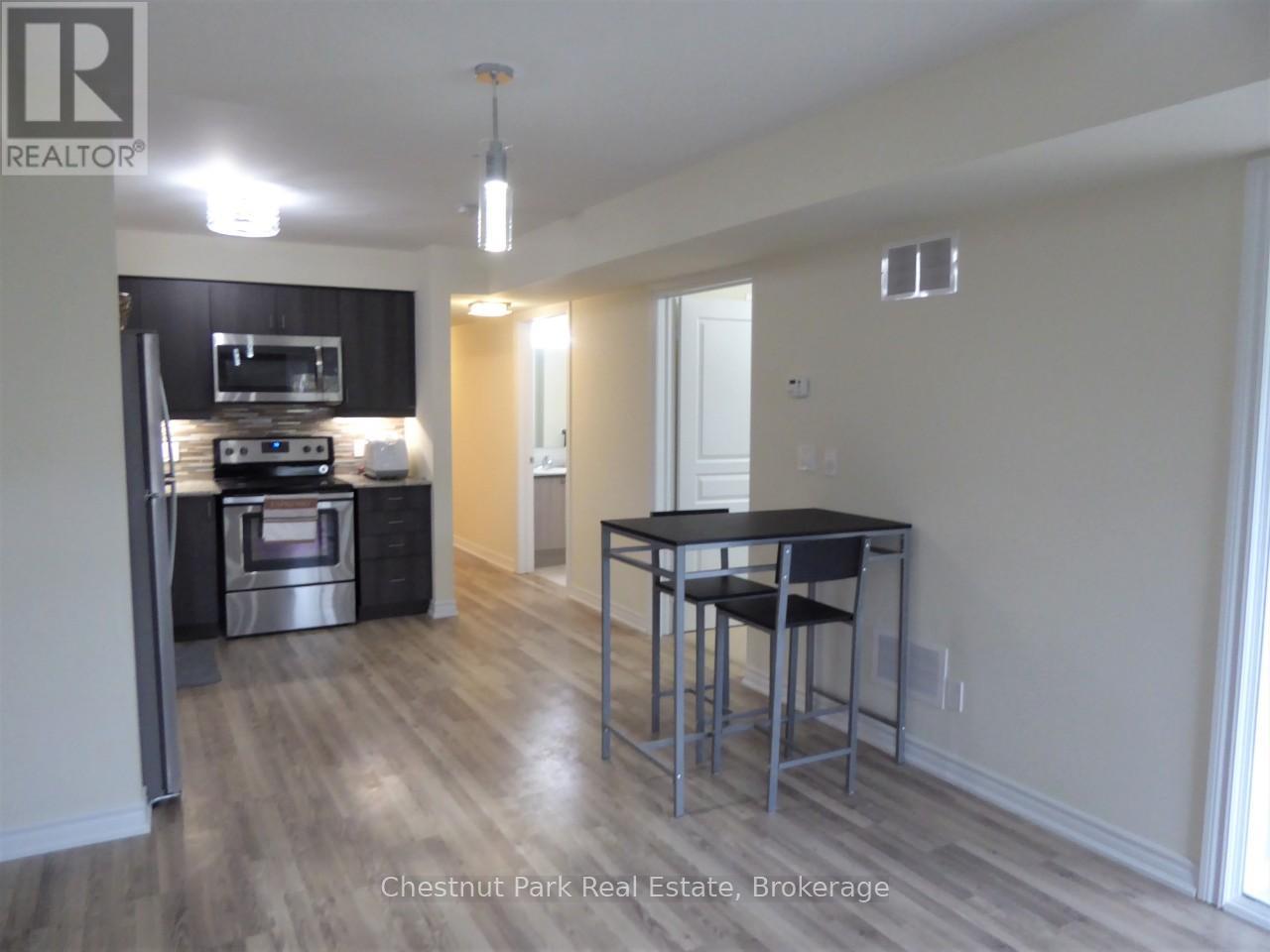 A kitchen with a black counter top and stainless steel appliances.